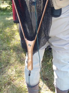 Trout Net - hanging from a magnetic release - Handle down - With green bungee lanyard.